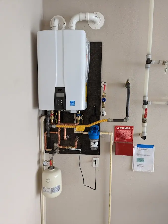 Professional plumber installing copper piping in a Grayling home